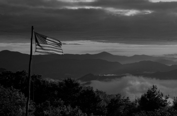 Black and White Image of American Flag flying over Appalachian Mountains